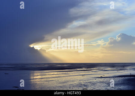 Sun shines behind dark clouds on the beach, Amrum, North Frisia, Schleswig-Holstein, Germany Stock Photo