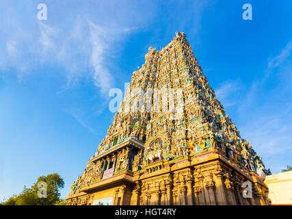 West tower gateway of Meenakshi Amman Temple covered in colorful statues of gods on a blue sky day at Madurai Stock Photo