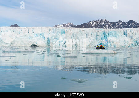 Zodiac with tourists navigating in front of Lilliehook glacier in Lilliehook fjord a branch of Cross Fjord, Spitsbergen Island, Stock Photo