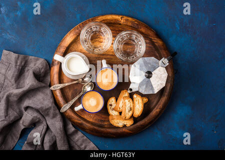 Coffee espresso, cantucci, cookies, milk and water on wooden board Stock Photo