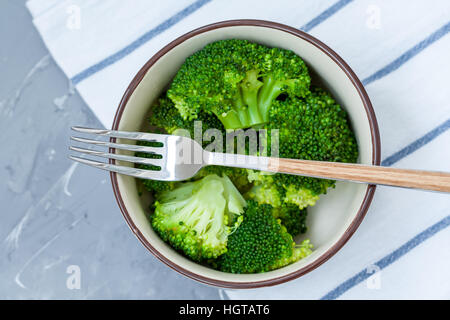 Boiled broccoli in a bowl on a concrete background. Stock Photo
