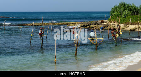 GALLE, SRI LANKA - MARCH 02:Fishermen on stilts trying to catch a fish on the pole on the coast of Sri Lanka. Galle on March 02, 2015 Stock Photo