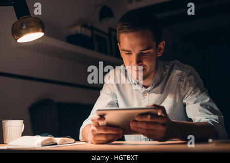 Young businessman working using a tablet late at night Stock Photo