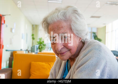 Portrait of elderly woman smiling and looking at the camera. Stock Photo