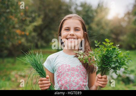 Cute little girl holding herbs outside Stock Photo