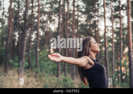 Young woman raising her arms to nature Stock Photo