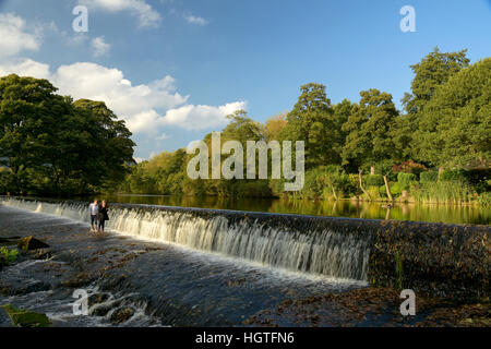 two small girls crossing weir on the river Derwent  Derbyshire England Stock Photo