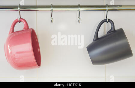 Two hanging mugs, one pink and one gray Stock Photo