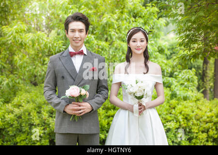 Young couple at a wedding smiling at the camera Stock Photo - Alamy