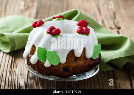 Easter sweet ring cake with glace icing and decoration on rustic wooden table Stock Photo