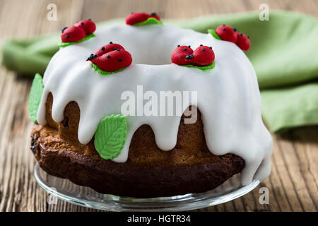 Easter sweet ring cake with glace icing and decoration on rustic wooden table Stock Photo