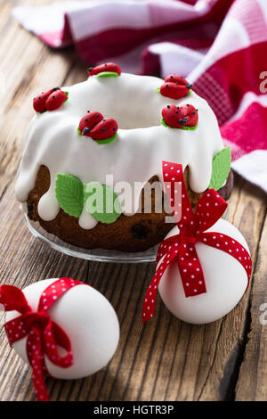 Easter sweet ring cake with glace icing and decoration on rustic wooden table Stock Photo
