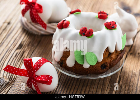 Easter sweet ring cake with glace icing and decoration on rustic wooden table Stock Photo