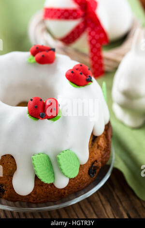Easter sweet ring cake with glace icing and decoration on rustic wooden table Stock Photo