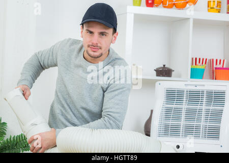 handsome technician installing air-conditioner in building Stock Photo