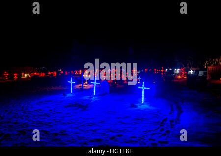 Illuminated crosses at a cemetery in South Iceland at night time in the snow, January 2017. Stock Photo