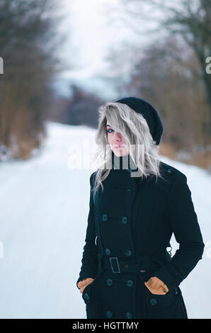 Beautiful gray haired hipster girl in black clothes on winter road Stock Photo