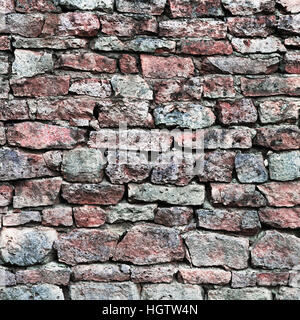 Stone wall closeup, stonewall pattern background, old aged weathered red and grey grunge limestone dolomite calcium carbonate hard sedimentary slate Stock Photo