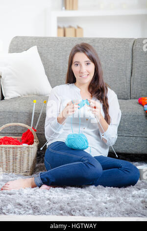 Lady sat on floor knitting Stock Photo