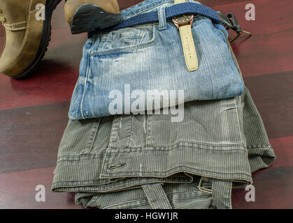 Rugged men fashion with  Jeans Belt jeans jacket watch and Brown suede leather shoes on wooden background. Stock Photo