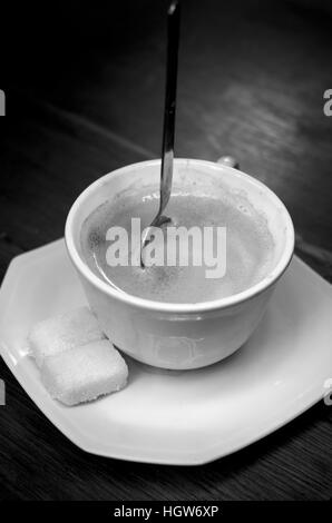 Very strong cup of coffee with spoon standing up in it (black and white) Stock Photo