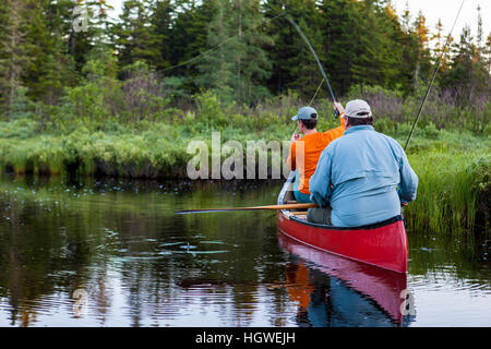 Two men fly-fishing for brook trout from a canoe on the Cold Stream 'deadwater' above Upper Cold Stream Falls in Maine's Northern Forest. Johnson Moun Stock Photo