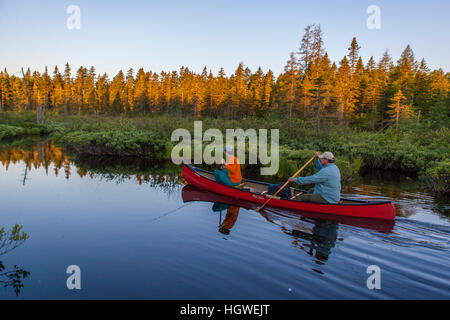 Two men fly-fishing for brook trout from a canoe on the Cold Stream 'deadwater' above Upper Cold Stream Falls in Maine's Northern Forest. Johnson Moun Stock Photo