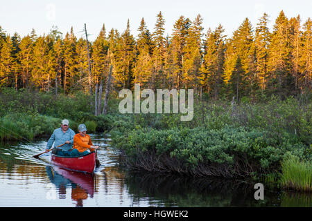 Two men fly-fishing for brook trout from a canoe on the Cold Stream 'deadwater' above Upper Cold Stream Falls in Maine's Northern Forest. Johnson Moun Stock Photo