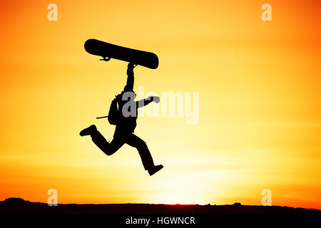 Happy snowboarder jump sunset ski Stock Photo