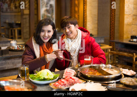 Young couple having dinner in hotpot restaurant Stock Photo