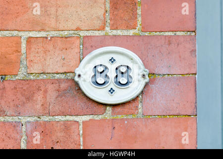 House Number 88 sign on red brick wall Stock Photo