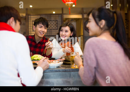 Young friends having dinner in hotpot restaurant Stock Photo