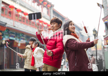 Young couple taking self portrait with smart phones Stock Photo