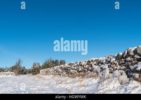 Winterland with a snow covered stone wall in a low perspective image Stock Photo