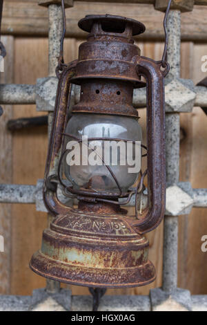 Old rusty kerosene lamp hanging on a metal grid in bulgarian village Zheravna Stock Photo