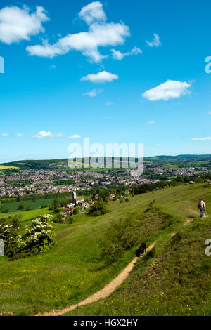 A man walks a dog on Selsley Common The view over Selsley village and the Stroud Valleys, Gloucestershire, Cotswolds, UK Stock Photo