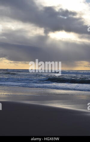 Sun peaks through the storm clouds over the Pacific Stock Photo