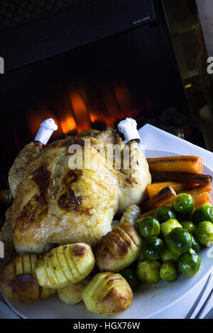 Whole Roast Chicken with potatoes and fresh cooked vegetables ready for serving. Stock Photo