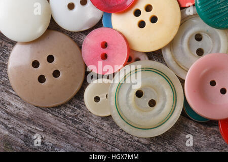 lots of colorful buttons close up on an old wooden table. macro Stock Photo