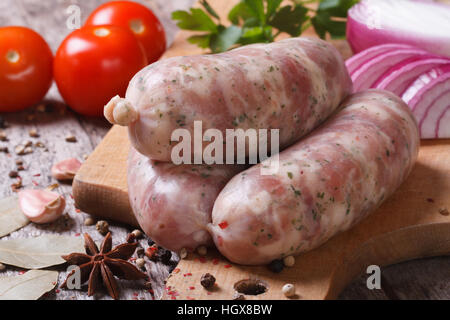 Raw sausage grill on kitchen board with ingredients closeup Stock Photo