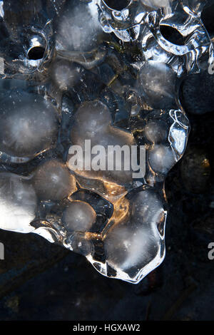 Dimpled patterns in sea ice on an Alaskan beach at sunset close up. Stock Photo