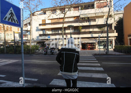 A woman walks over a zebra crossing in Lido, Venice, Italy. Stock Photo