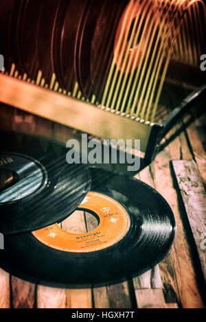 Classical vinyl singles and a record stand on a wooden floor Stock Photo