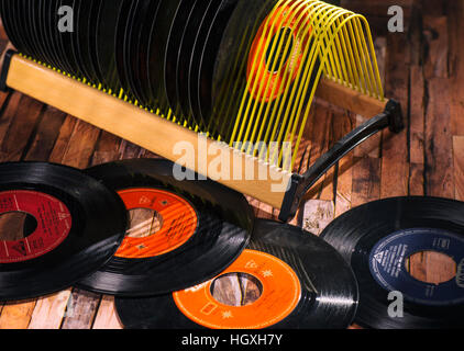 Classical vinyl singles and a record stand on a wooden floor Stock Photo