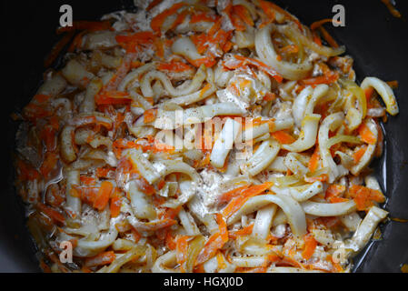 Calamaries stewed in cream sauce with carrots in pan Calamaries stewed in cream sauce with carrots in pan