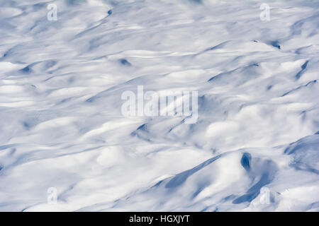 Layers of snow mask deep crevasse on the surface of the vast Greenland Ice Sheet plain. Stock Photo