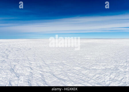 Layers of snow mask deep crevasse on the surface of the vast Greenland Ice Sheet plain. Stock Photo