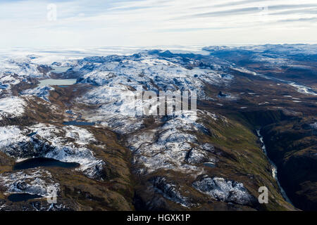 A dusting of snow covers mountain peaks on a highland tundra plateau. Stock Photo