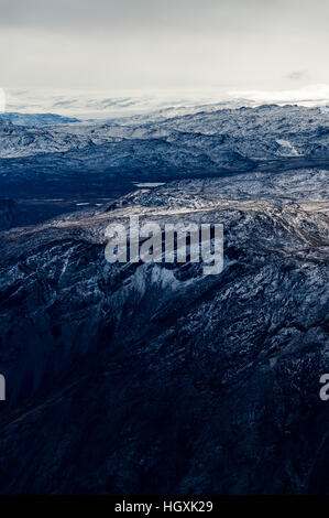 A dusting of snow covers barren and inhospitable mountain peaks on a highland tundra plateau. Stock Photo