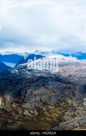 A dusting of snow covers mountain peaks on a highland tundra plateau. Stock Photo